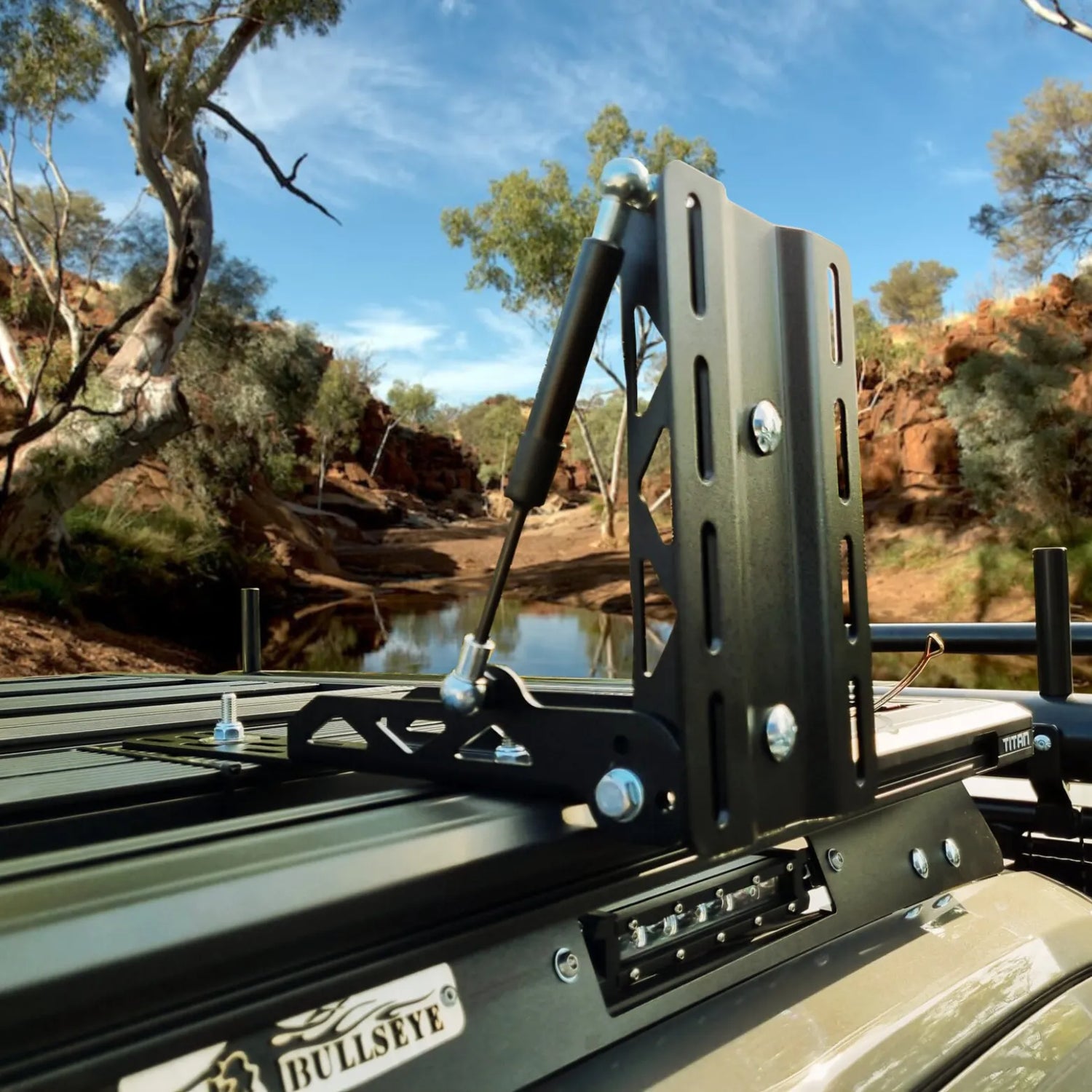 Roof rack mounted on a vehicle with a scenic background of trees and water.